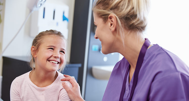 Doctor laughing with young girl