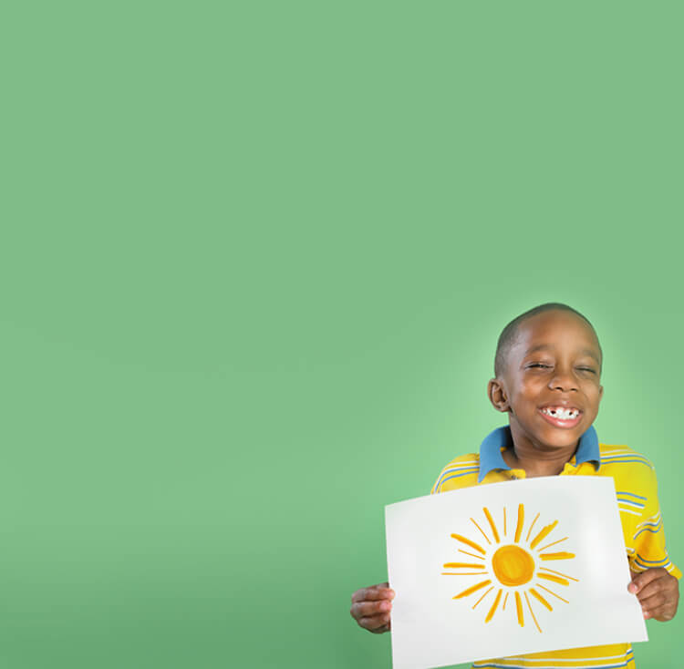 Boy smiling while holding painting of sun